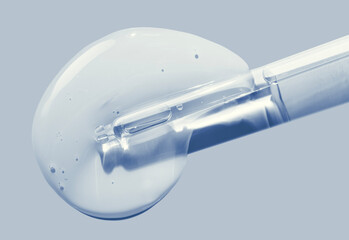 Liquid blue transparent serum with pipette on blue gray background