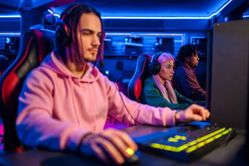 Few gamer friends with headset sitting having lan party at gaming lounge. © Zamrznuti tonovi