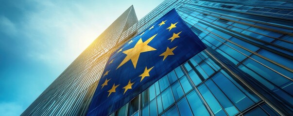European Union flag with blue and yellow star design waving on modern glass building reflecting sunlight