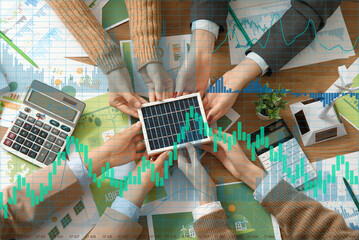 Business team with solar panel working on green energy strategies during office meeting, top view