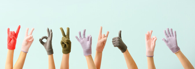 Women in warm gloves showing different gestures on blue background