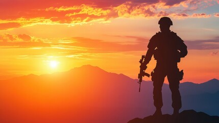 Fototapeta premium Soldier standing on a mountain peak at sunset, silhouetted against a colorful sky in the evening