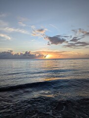 Vertical photo of sunset at cozumel island, sun centered, cloudy sky