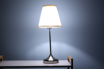 Glowing lamp on shelving unit in dark room