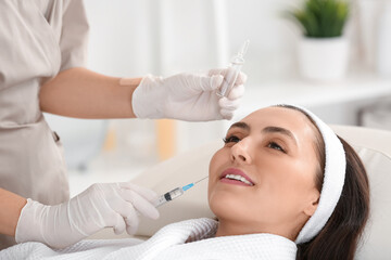 Beautiful young woman receiving injection in beauty salon, closeup