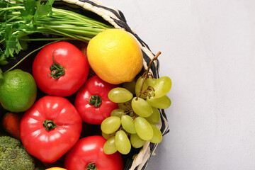 Wicker bowl with different fresh fruits and vegetables on white background, closeup