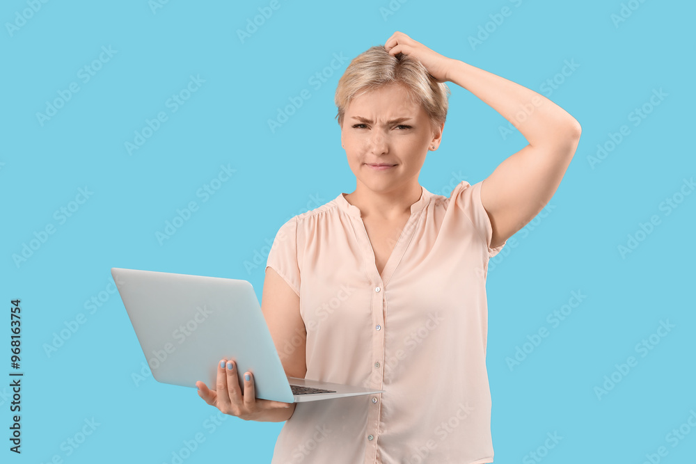 Wall mural thoughtful young female programmer with laptop on blue background