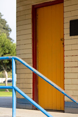 Naklejka premium yellow door with red border and yellow brick wall with blue detailing