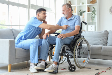 Obraz premium Male nurse hearing senior man in wheelchair with stethoscope at home