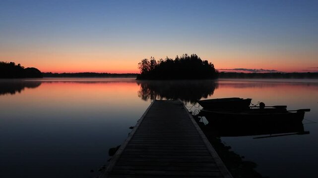 Jetty with boat at the Stora Hensj&ouml;n lake in Sweden at dawn.