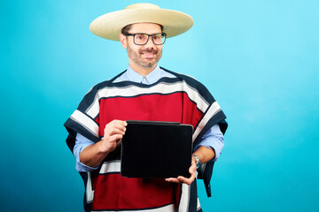 Hombre con ropa tradicional de Huaso mostrando una tableta digital con espacio de copia, concepto...