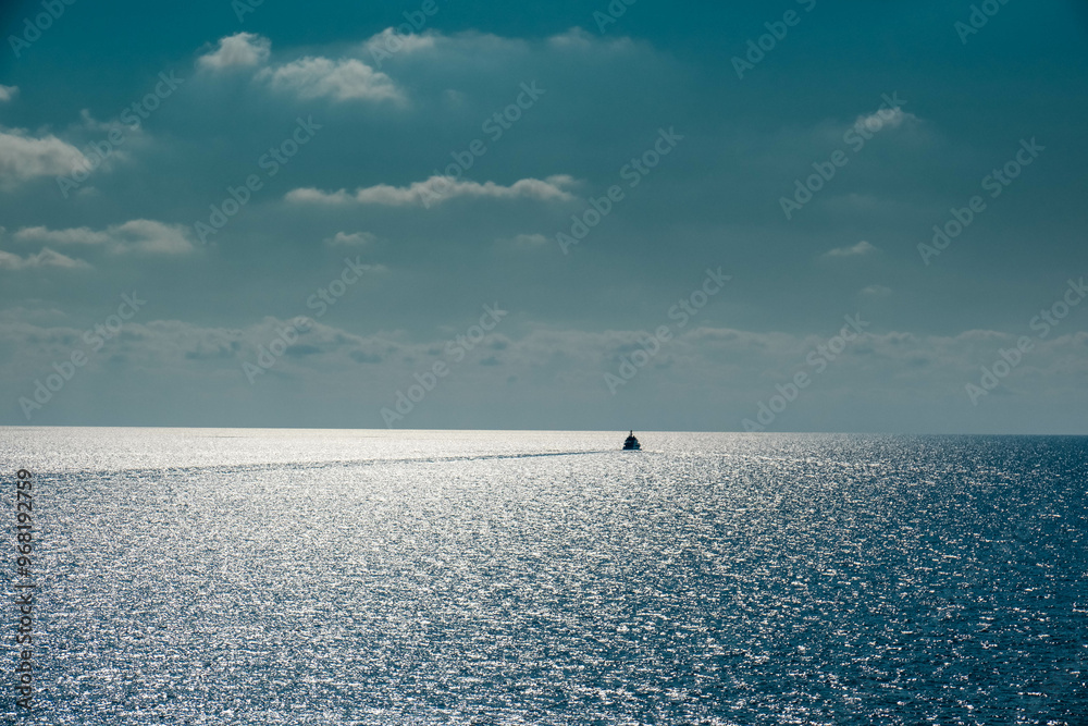 Wall mural boat in the middle of the sea sails alone among the waves to the horizon on a late summer day in 202