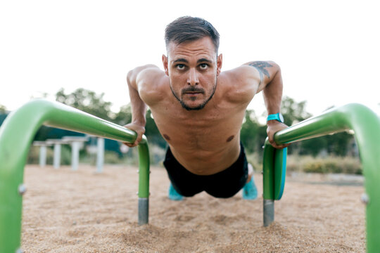 Man performing calisthenics workout at outdoor park