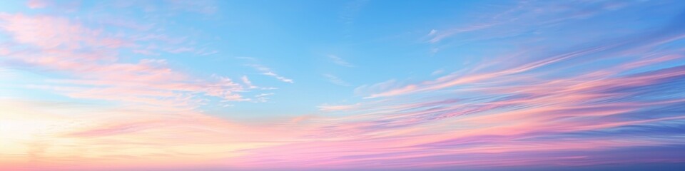 Fototapeta premium Pastel Sunset Sky Panoramic Image Featuring Soft Pink, Golden, and Blue Evening Tones with Long Stratus Clouds on the Horizon, Capturing a Serene Skyscape in Gentle Hues, Highlighting Nature�s Beauty.
