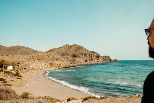 Scenic view of Isleta del Moro beach with a man&rsquo;s profile in the foreground