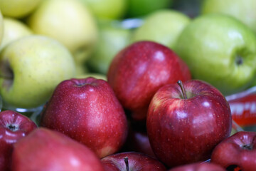 Fresh red and green apples as background, selective focus. Jewish holiday Rosh Hashana. Traditional food of New Year Rosh Hashanah concept. Jewish new year composition of an apple, festive backdrop.
