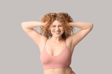 Fototapeta premium Beautiful young happy body positive woman in trendy underwear on grey background
