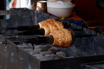 kurtoskalac is made from sweet, yeast dough (raised dough), of which a strip is spun and then...