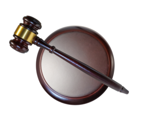 wooden gavel resting on a round sound block isolated on white background