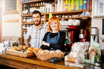 Portrait, man and woman at bakery counter with confidence, smile and partnership for small business owner at cafe. Entrepreneur, teamwork and happy couple at coffee shop for service in Ireland