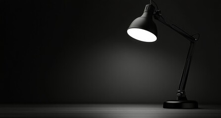 A black desk lamp illuminating a dark workspace in a minimalistic setting at night