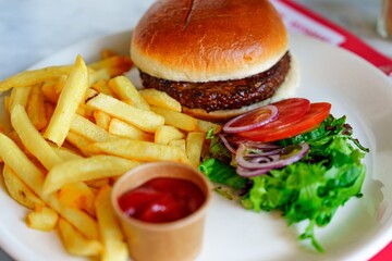 A juicy beef burger served with crispy fries and a fresh salad. Made with quality ground beef, topped with melted cheese, lettuce, tomato, and onion on a toasted bun. Perfect for lunch or dinner.