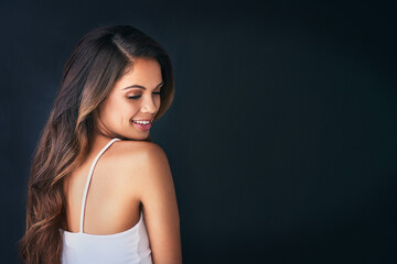 Naklejka premium Woman, balayage and curls in studio for haircare, grooming and hairstyle on black background. Female person, healthy locks and treatment for texture on mockup space, long and highlights for cosmetics
