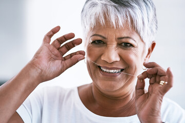 Elderly, portrait and happy woman with dental floss for hygiene, dentist or tooth cavity at home. Senior woman, face and smile with string for cleaning teeth, gum or mouth and oral care at house