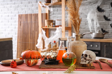 Halloween pumpkins with potions and skull on dining table in kitchen