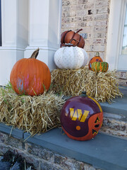 Pumpkins, straw and flowers on the steps of a house for Halloween and Thanksgiving.