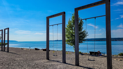 Giant swings on the beach, on the bank of the blue lake or sea. Place for relax and entertainment.