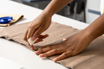 Dressmaker working on clothing projects using material in a professional studio