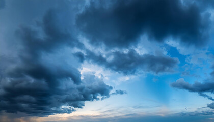 Obraz premium Dramatic sky at evening panoramic shot. Scenic blue gray clouds before the storm. Overcast cloudscape before the rain. Blue hour stormy cloudscape. Dark thunderstorm sky wide image. Sky only.