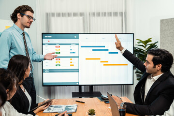 Project manager planning schedules for business task at meeting room, Gantt chart software show on TV screen. Multi ethnic diversity business people and modern business project management. Habiliment