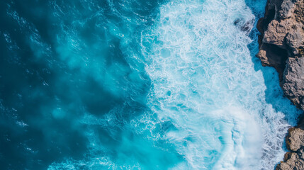Aerial view of crashing ocean waves against rugged coastal cliffs, dramatic water movement, deep blue sea and white foam, powerful and serene