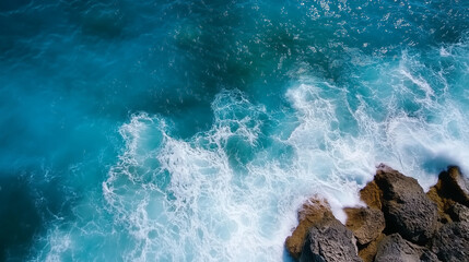 Obraz premium Coastal waves crashing onto rugged rocks, dynamic aerial perspective, deep blue waters with white foam, dramatic and powerful ocean scene