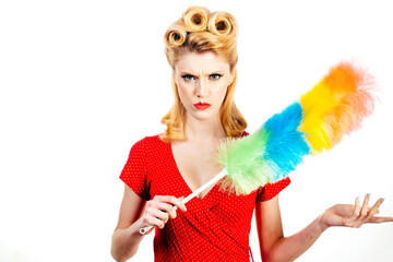 Funny Crazy young pinup housewife wearing retro outfit and rubber gloves dusting furniture. Domestic work, house chores concept. Duster, woman and cleaning dust in home for housekeeping.