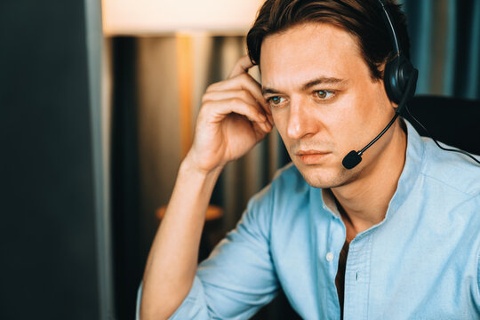 Call center consulting with customers on headphones on monitor in business paragraph with typing on pc with dynamic data marketing analysis planning at modern home office at night time. Pecuniary.