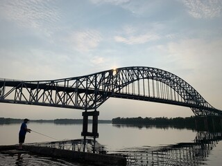 bridge over river and fisherman