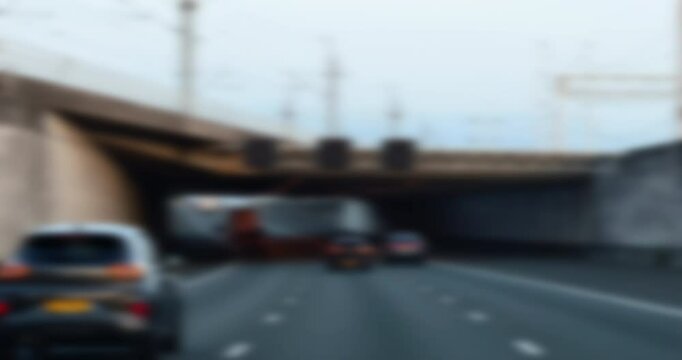 Defocused slow-motion view of a driver on a large highway with a car ahead, portraying a blurry and disoriented perspective, symbolizing the concept of impaired driving