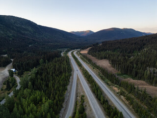 Scenic Aerial View of Highway Through Forested Mountains in British Columbia, Canada at Dusk