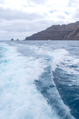 a trail of foam from a boat on the ocean water, Lanzarote Island, Canary Islands, Point of Fariones, cape of Fariones,, vertical
