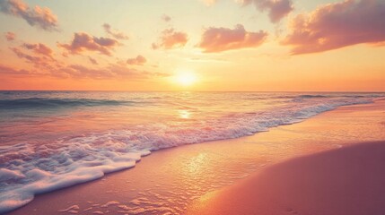 A sandy beach at sunset, with the sky ablaze in orange and pink hues, and waves gently lapping the shore.