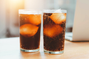 Glass of cola, Double cool ice soft drink cola carbonated liquid fresh food with soda water, Cola drinking with ice in glass ready to refresh you, A cola soft drink is placed on the desk.