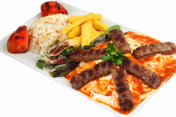 Plate of traditional grilled meatballs on white background