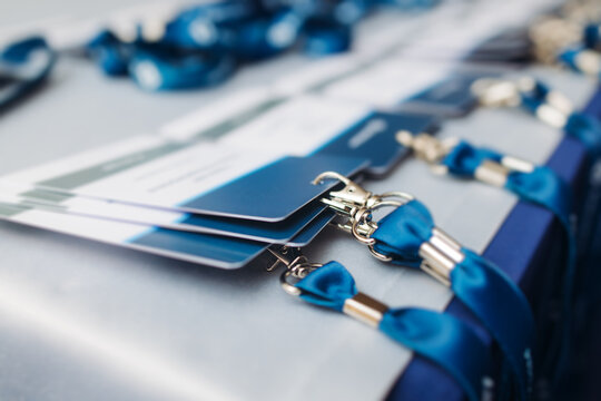 Process of checking in on conference congress forum event, registration desk table, visitors and attendees receiving lanyard with name badge and entry wristband bracelet and register electronic ticket