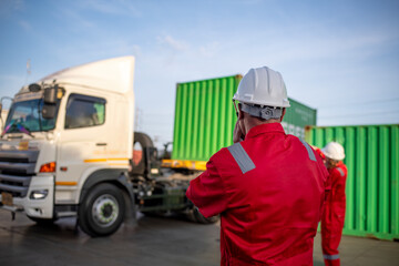 Engineer or worker standing forklift or truck vehicle are holding detail and appear to be...