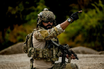 A group of military men in combat gear patrol in the middle of a desert and tropical jungle....