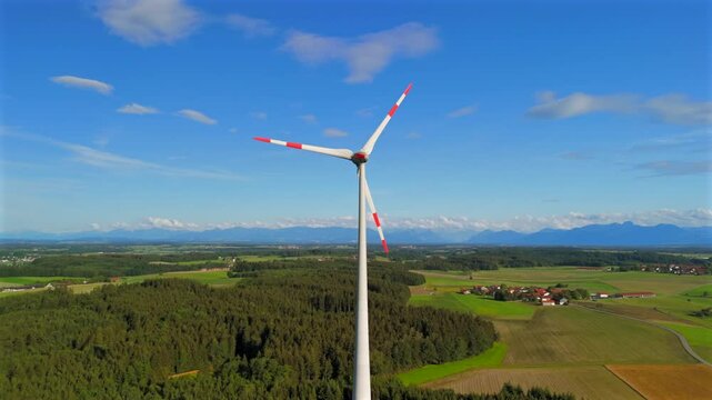 Aerial view of wind turbine in Bavaria, Ebersberg region, Germany. Luftaufnahme einer Windturbine vor dem Hintergrund der Alpen in Bayern, Deutschland. Wind turbine on golf course overlooking alps. 