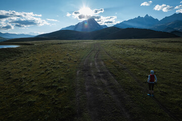 Fototapeta premium Aerial view of woman trail runner in high altitude mountains